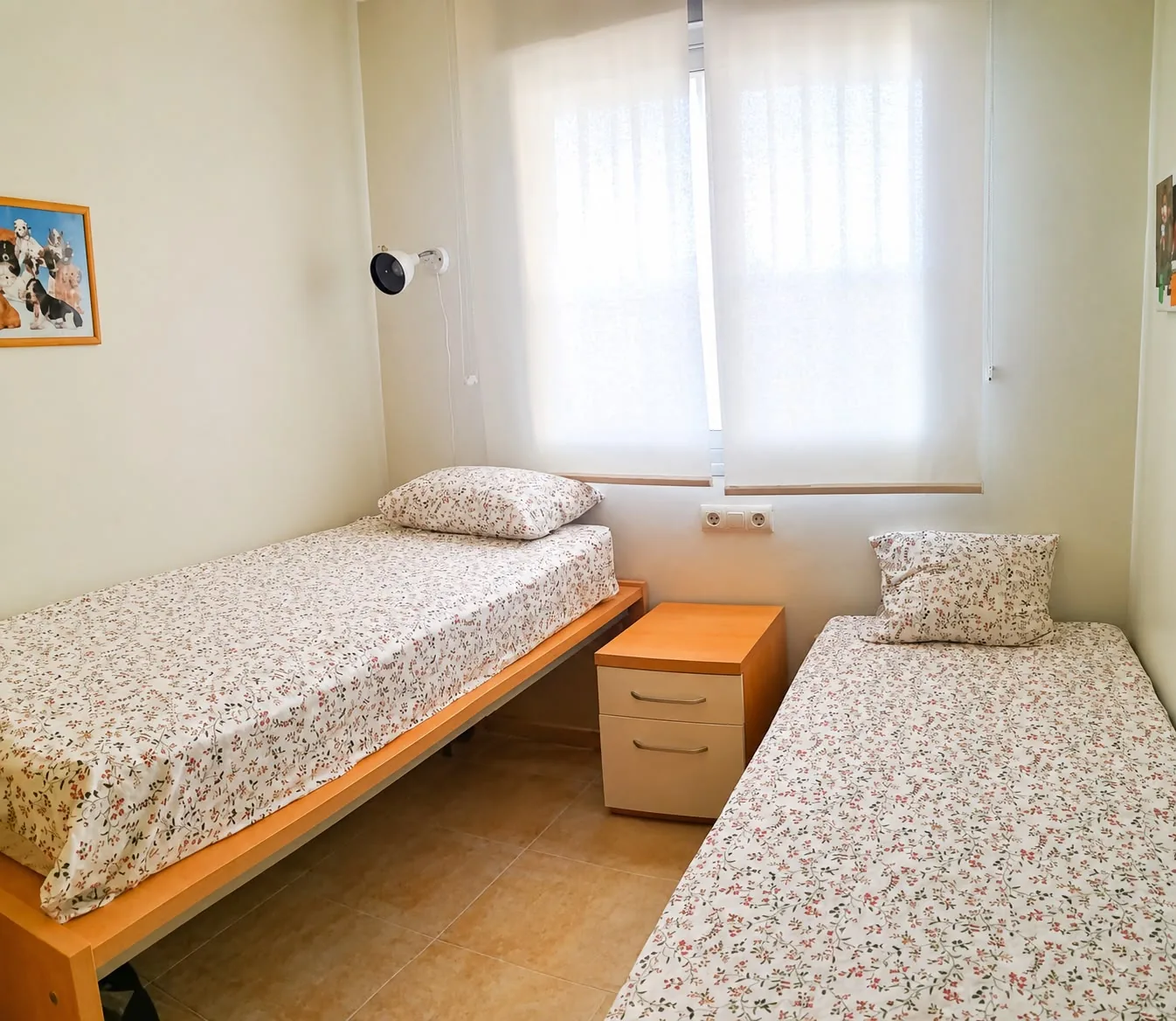 Chambre avec deux lits simples et table de chevet