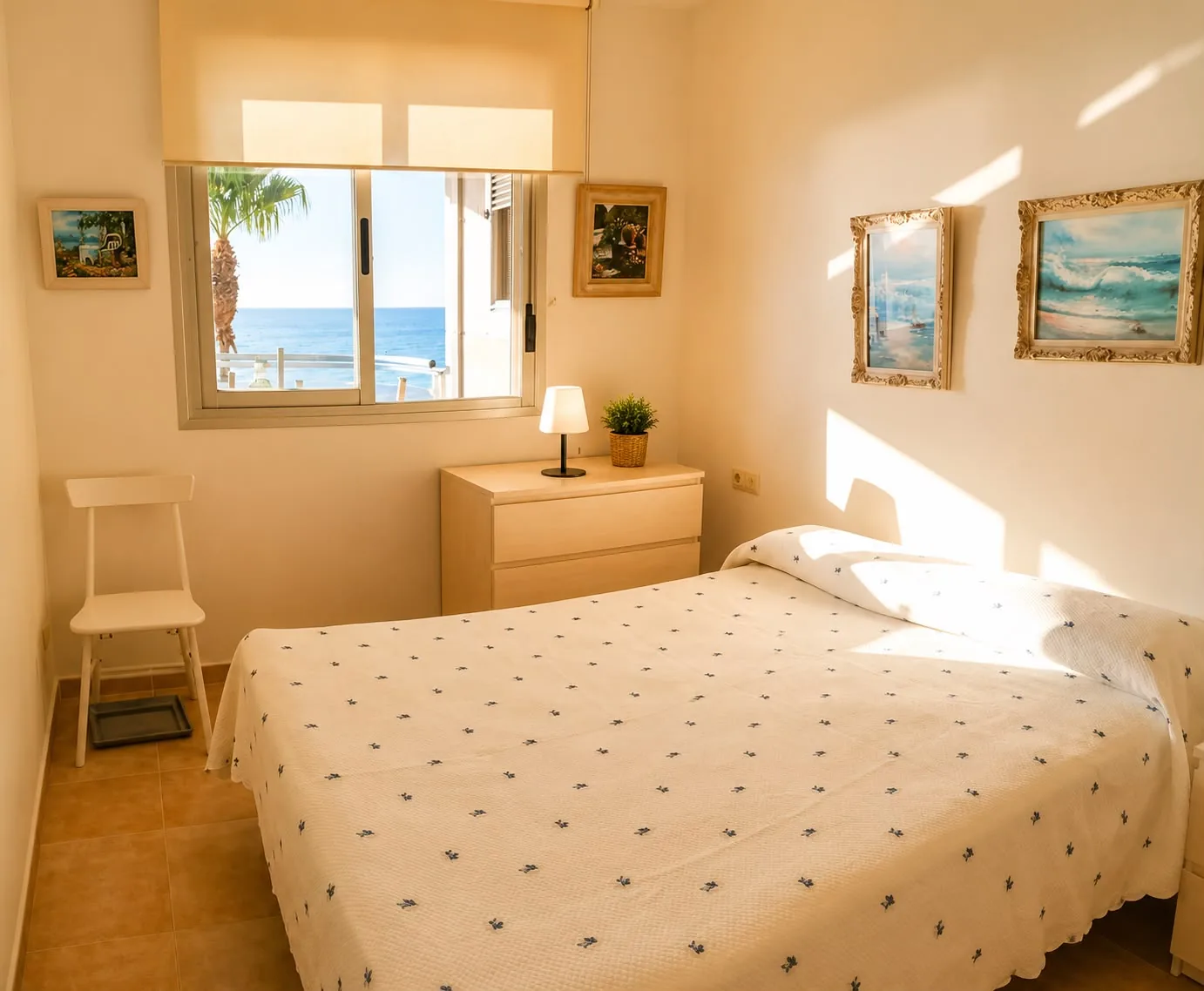 Chambre avec lit double, commode et fenêtre donnant sur la mer