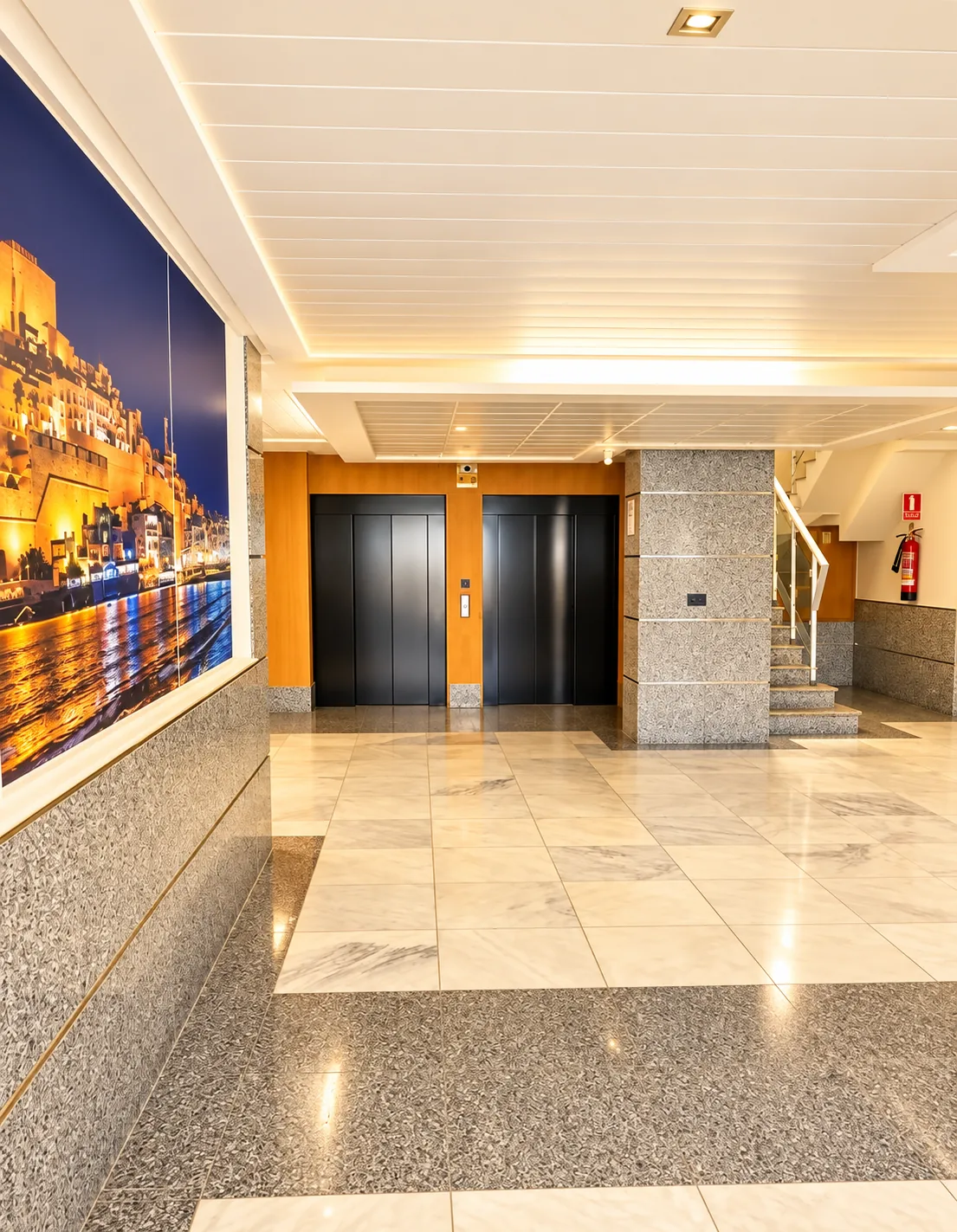 Hall de l'immeuble avec deux ascenseurs, escalier et fresque de Peñíscola